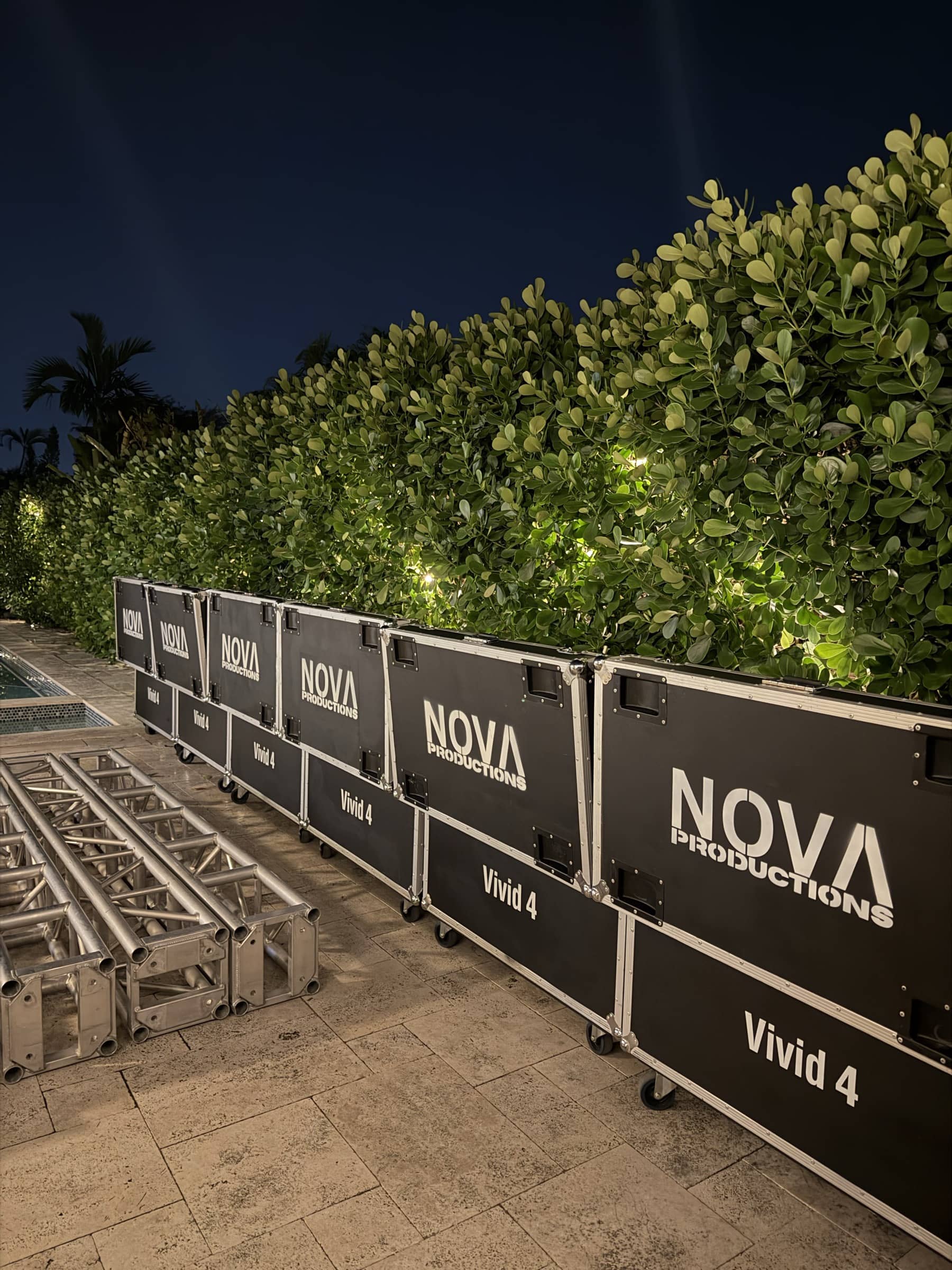 Nova LED panel road cases and truss staged along the hedge at night