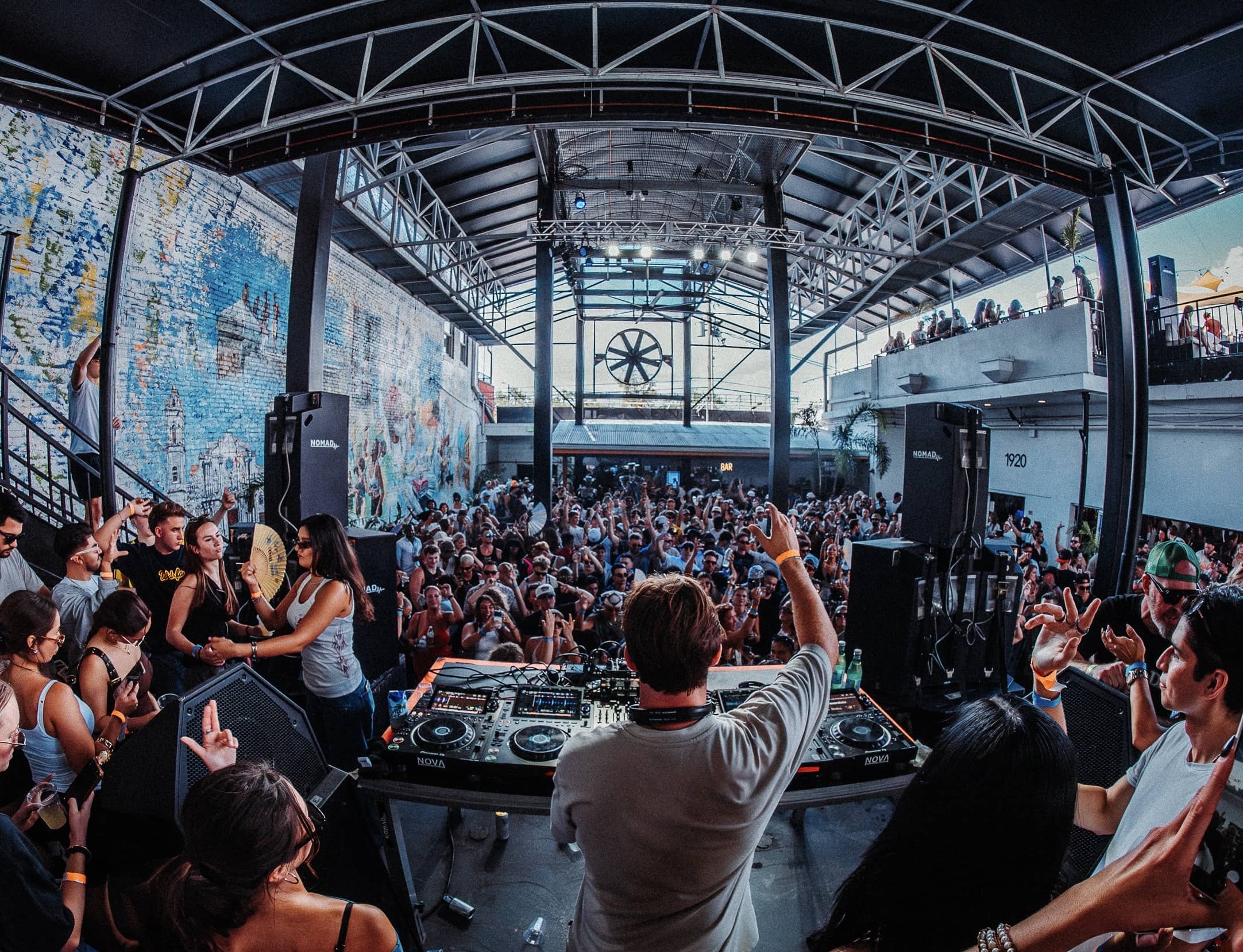 Wide view from the stage: crowd, mezzanine and roof structure in daylight